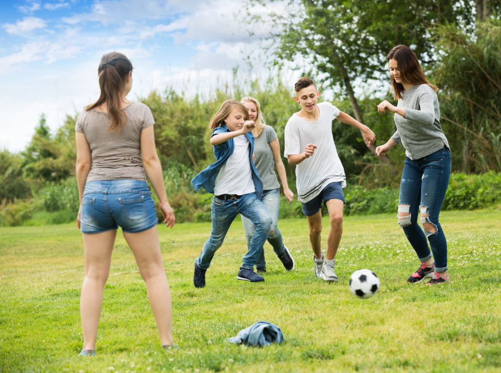 Young people playing football in the park