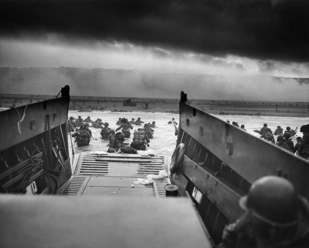 A photo from 1944 of soldiers jumping from their landing craft on Normandy Beach during D-Day.