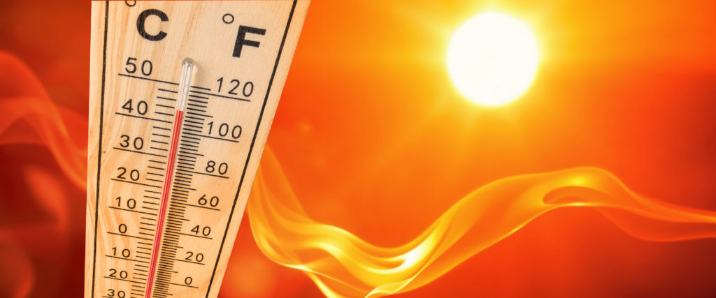 An illustration of a thermometer with the temperature reaching the maximum, with an orange sky and sun in the background.