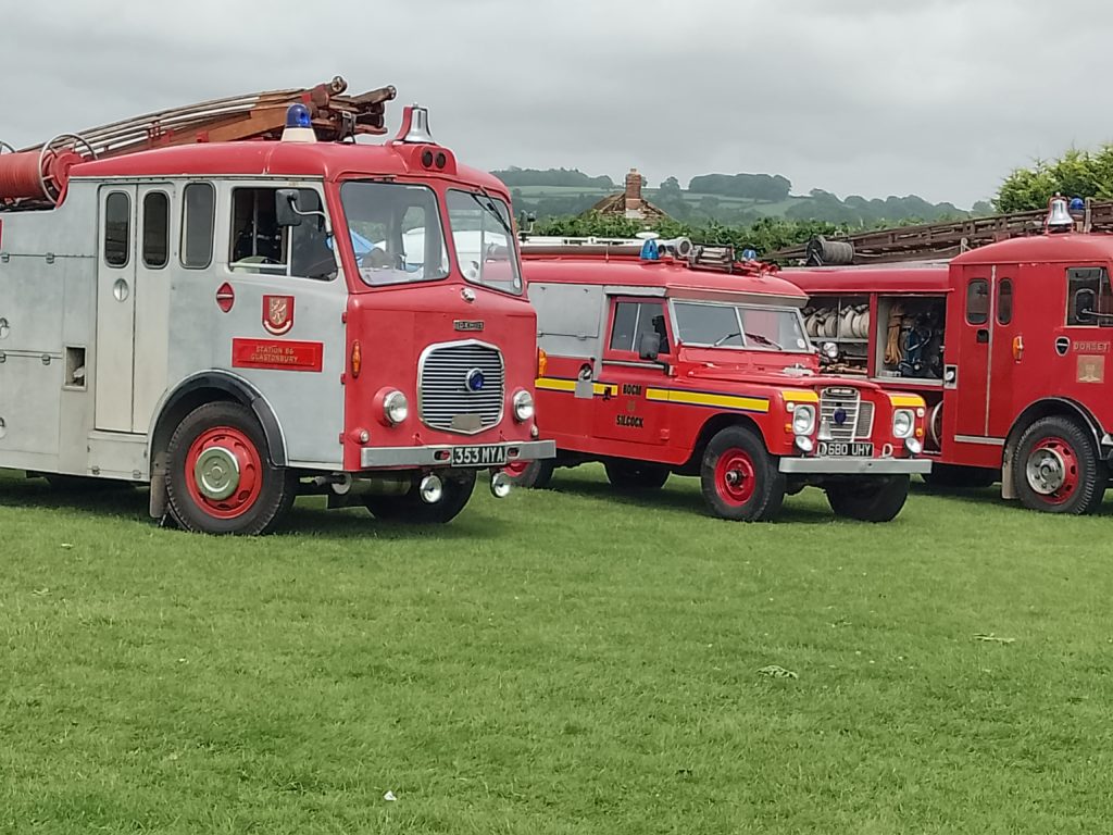 A photo of three vintage red fire engines