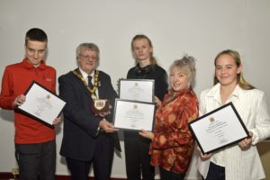 Elected Somerset Members of Youth Parliament Luca, Blake and Eve, Engagement and Participation Officer Kate receive their awards from Councillor Mike Best.